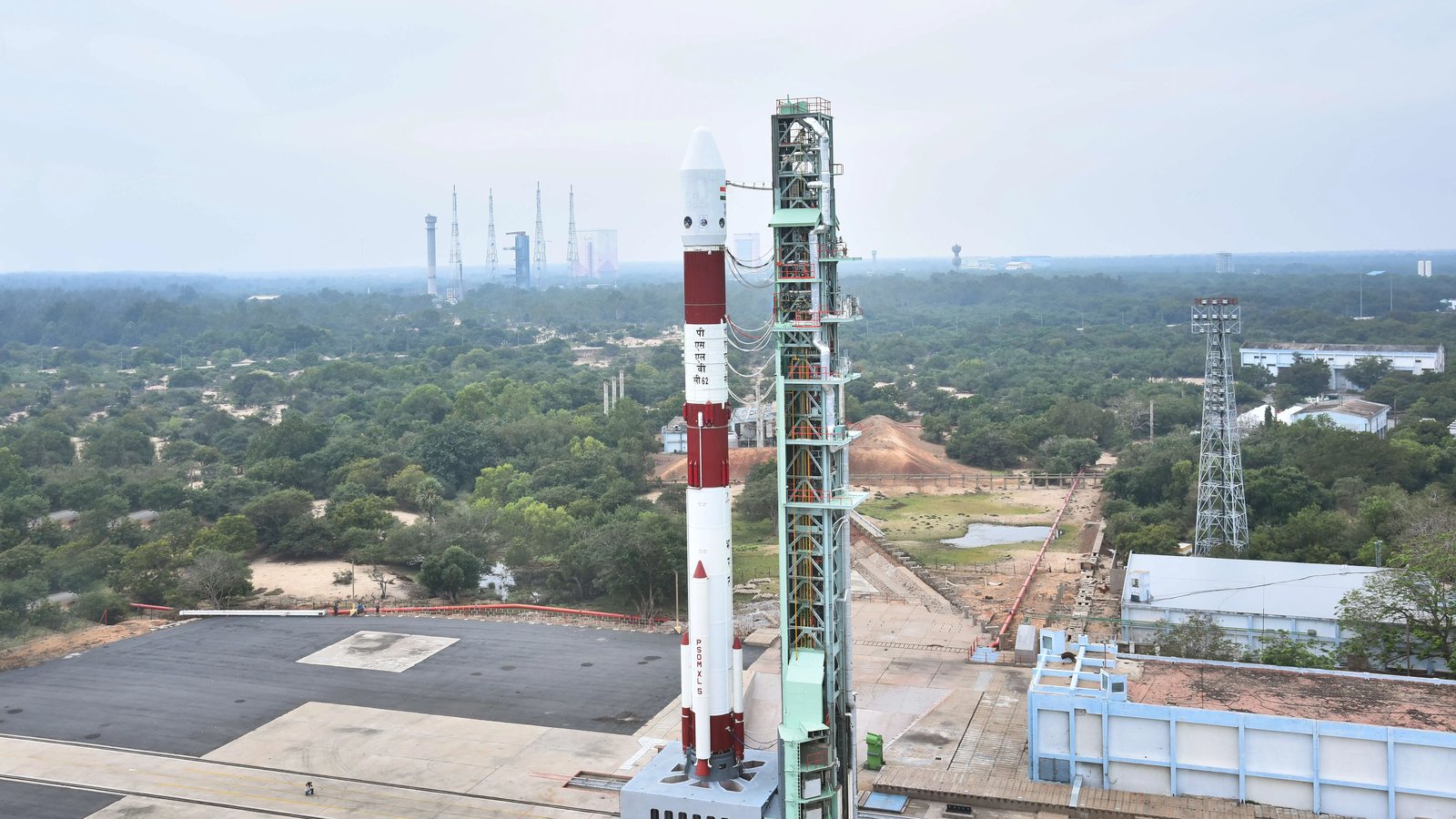 An aerial view of a PSLV rocket on its launch pad at Sriharikota, surrounded by green land