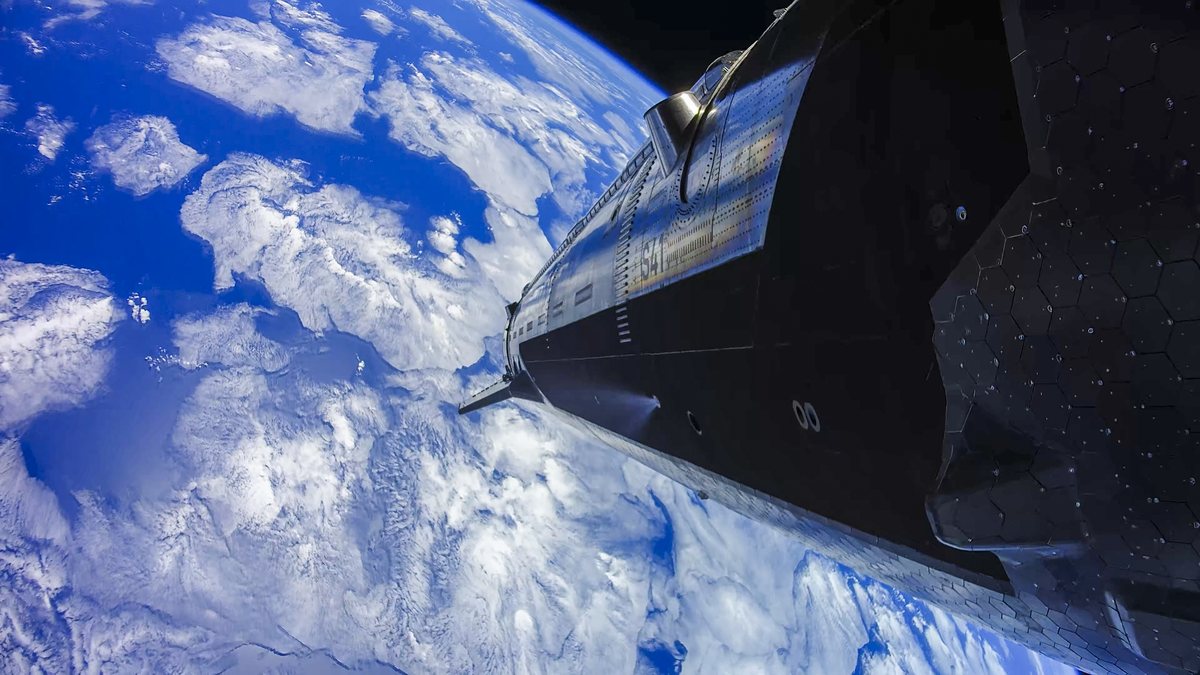 Camera view of the ship, marked S41, with its black heat-shield tiles, flying above white clouds and blue ocean